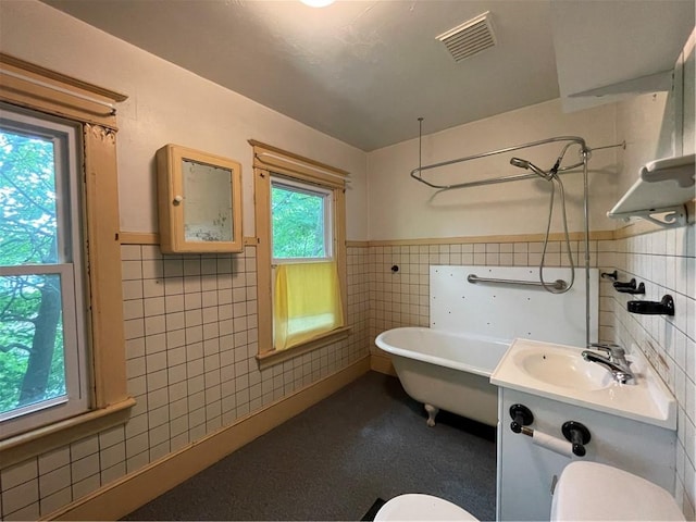4 Third St, Oneonta, NY 13820 - bathroom with tile walls, a soaking tub, wainscoting, and vanity