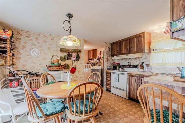 218 Campbell Rd, Gouverneur, NY 13642 - kitchen with white appliances, under cabinet range hood, wallpapered walls, washer / dryer, and light countertops