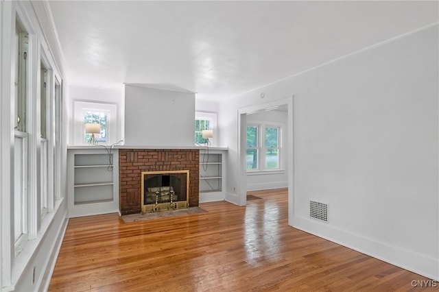 201 Mosley Dr, Syracuse, NY 13206 - unfurnished living room with wood finished floors, a fireplace, and healthy amount of natural light