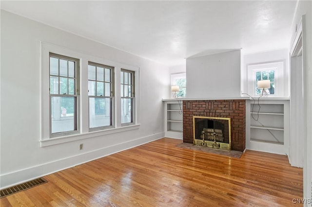 201 Mosley Dr, Syracuse, NY 13206 - unfurnished living room with wood finished floors and a brick fireplace