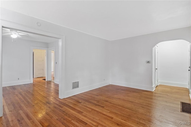 201 Mosley Dr, Syracuse, NY 13206 - spare room featuring wood finished floors, arched walkways, a ceiling fan, and a smoke detector