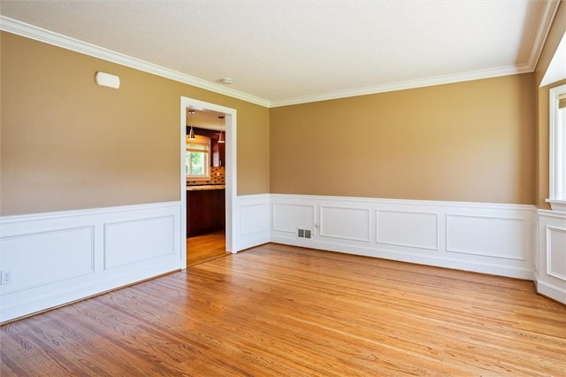 179 Down St, Henrietta, NY 14623 - empty room featuring light wood-style flooring, crown molding, and wainscoting