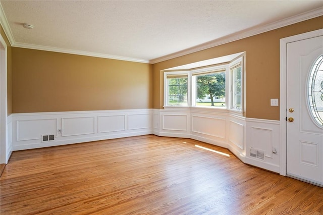 179 Down St, Henrietta, NY 14623 - foyer with crown molding, light wood-style floors, a wainscoted wall, and a decorative wall