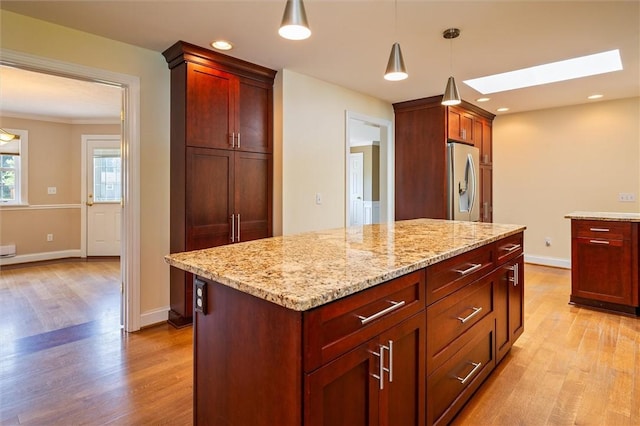 179 Down St, Henrietta, NY 14623 - kitchen with stainless steel fridge with ice dispenser, light wood-style floors, a skylight, light stone counters, and recessed lighting
