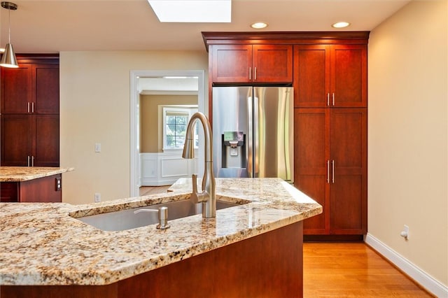 179 Down St, Henrietta, NY 14623 - kitchen featuring stainless steel refrigerator with ice dispenser, dark brown cabinets, light wood-style floors, light stone counters, and recessed lighting