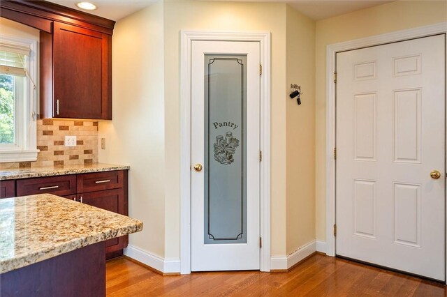 179 Down St, Henrietta, NY 14623 - kitchen featuring light wood-style flooring, backsplash, and light stone counters