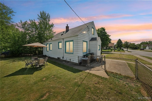 167 Somerville Ave, Tonawanda, NY 14150 - back of house at dusk with a chimney and a gate