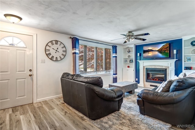 1416 99th St, Niagara Falls, NY 14304 - living area featuring ceiling fan, light wood finished floors, a glass covered fireplace, built in features, and a textured ceiling