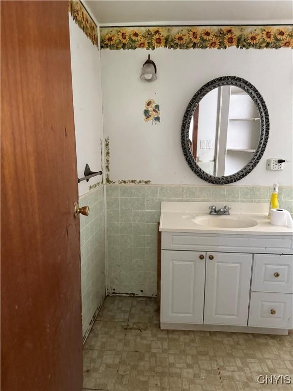211 W Park St, Lenox, NY 13032 - bathroom featuring vanity, tile walls, and wainscoting