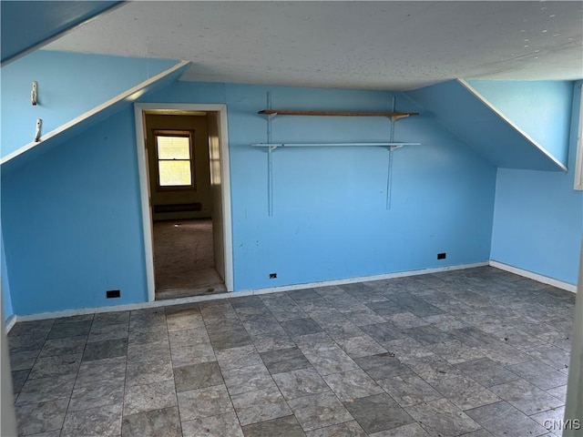 211 W Park St, Lenox, NY 13032 - additional living space featuring baseboard heating, lofted ceiling, and a textured ceiling
