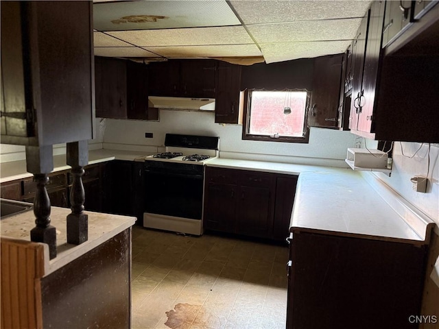 211 W Park St, Lenox, NY 13032 - kitchen featuring gas range oven, a paneled ceiling, under cabinet range hood, light countertops, and light flooring