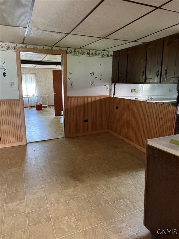 211 W Park St, Lenox, NY 13032 - kitchen with wainscoting, a paneled ceiling, dark brown cabinetry, and light countertops
