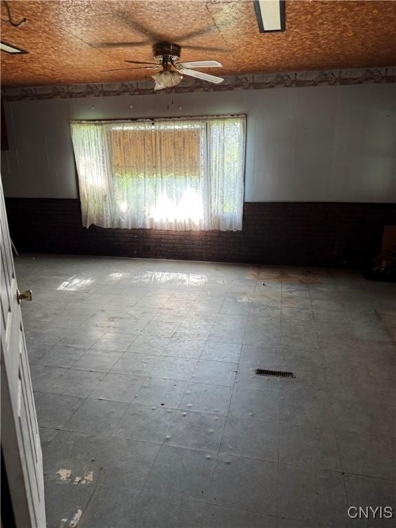 211 W Park St, Lenox, NY 13032 - unfurnished room featuring tile patterned floors, ceiling fan, and brick wall