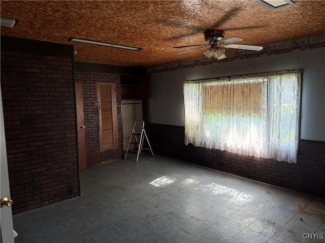 211 W Park St, Lenox, NY 13032 - spare room with brick wall, ceiling fan, tile patterned floors, and plenty of natural light