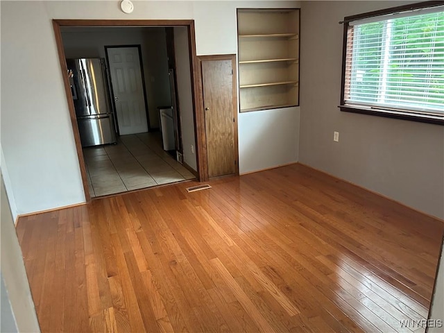38 Hines St, Buffalo, NY 14220 - unfurnished bedroom with stainless steel fridge and light wood-type flooring