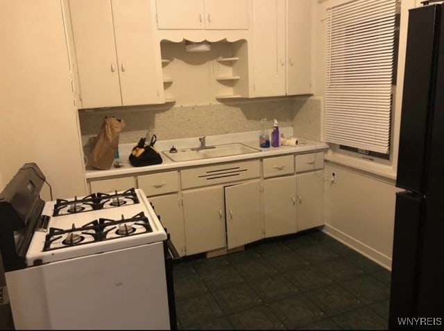 83 Custer St, Buffalo, NY 14214 - kitchen with white gas range, freestanding refrigerator, open shelves, white cabinets, and light countertops