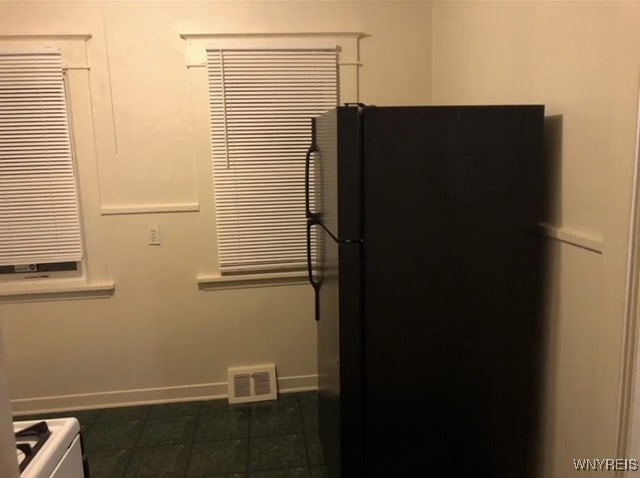 83 Custer St, Buffalo, NY 14214 - kitchen with freestanding refrigerator and dark tile patterned floors