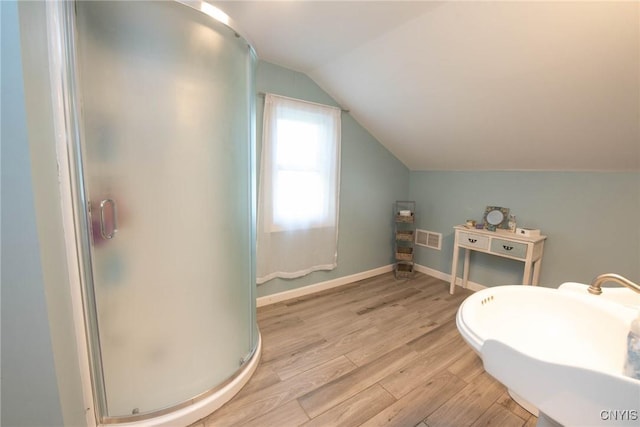 1109 Church Rd, Lysander, NY 13027 - bathroom with vaulted ceiling, a stall shower, and wood finished floors
