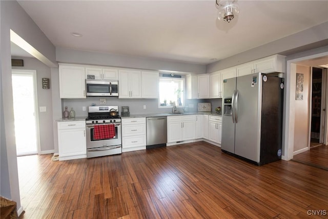 1109 Church Rd, Lysander, NY 13027 - kitchen featuring stainless steel appliances, light countertops, white cabinetry, and dark wood-style flooring