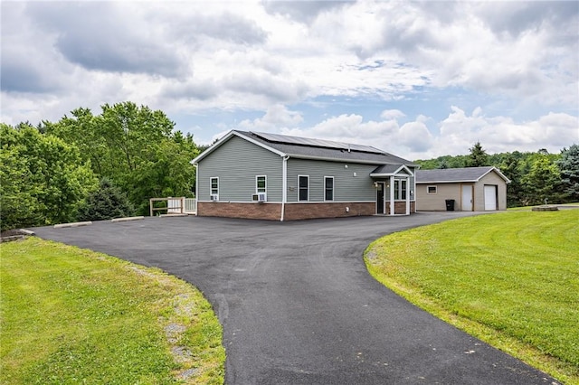 7156 County Line Rd, Naples, NY 14512 - view of front of home featuring brick siding, roof mounted solar panels, a front yard, and a detached garage
