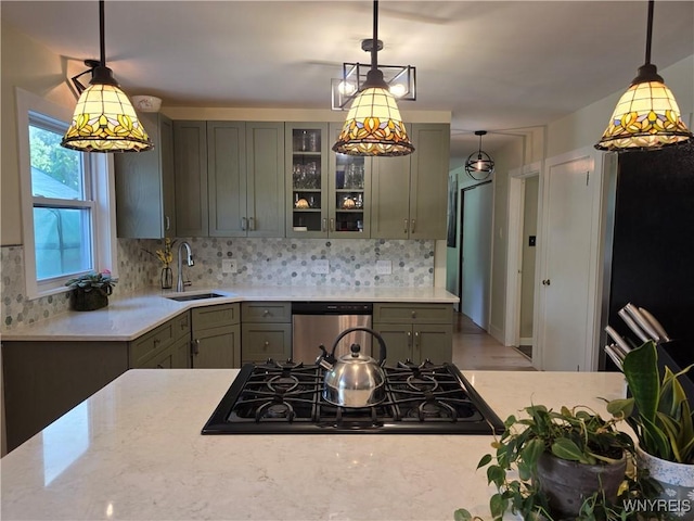 4049 River Rd, Lewiston, NY 14174 - kitchen with black gas cooktop, stainless steel dishwasher, glass insert cabinets, decorative backsplash, and pendant lighting