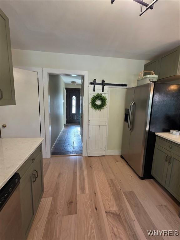 4049 River Rd, Lewiston, NY 14174 - kitchen with appliances with stainless steel finishes, light wood-style flooring, a barn door, and gray cabinetry
