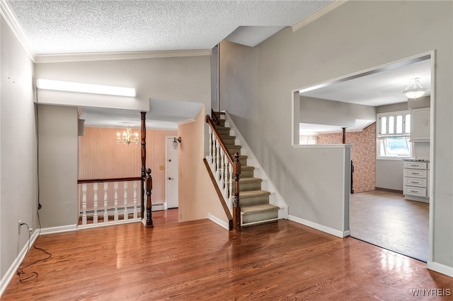 17 Frantzen Ter, Cheektowaga, NY 14227 - foyer featuring a chandelier, a baseboard heating unit, wood finished floors, crown molding, and a textured ceiling