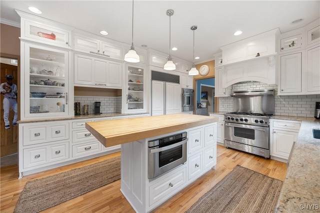 8067 Irish Mist Ln, Manlius, NY 13104 - kitchen featuring high end appliances, butcher block countertops, crown molding, white cabinets, and decorative backsplash
