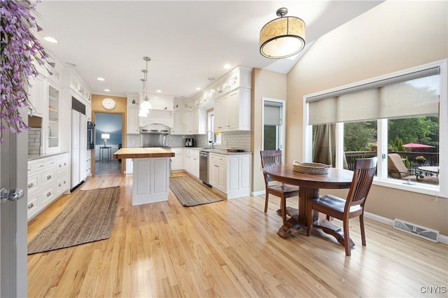 8067 Irish Mist Ln, Manlius, NY 13104 - kitchen featuring stainless steel dishwasher, butcher block countertops, white cabinets, tasteful backsplash, and a center island
