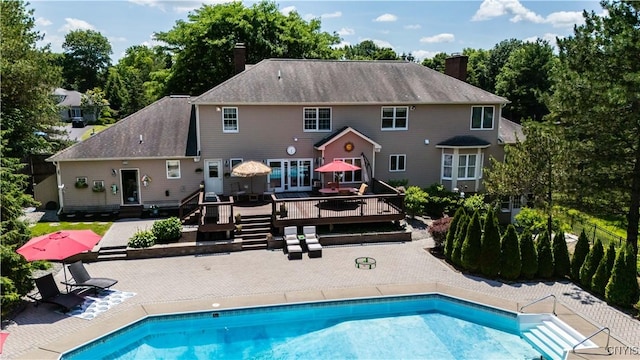 8067 Irish Mist Ln, Manlius, NY 13104 - back of house featuring a wooden deck, a chimney, a patio, and an outdoor pool