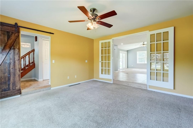 11 Hillcrest Dr, Hamlin, NY 14464 - unfurnished room featuring a barn door, ceiling fan, carpet flooring, french doors, and stairs