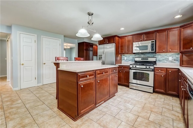 11 Hillcrest Dr, Hamlin, NY 14464 - kitchen featuring appliances with stainless steel finishes, light countertops, light tile patterned flooring, a kitchen island, and recessed lighting
