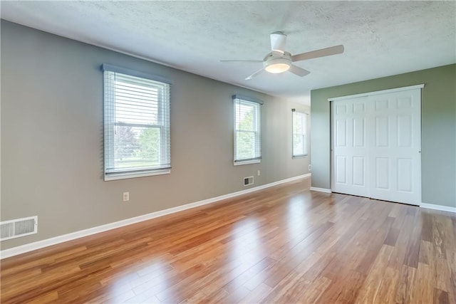 11 Hillcrest Dr, Hamlin, NY 14464 - unfurnished bedroom with light wood-style flooring, a closet, a textured ceiling, and a ceiling fan