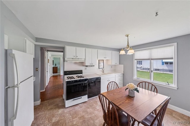 66 Gierlach St, Cheektowaga, NY 14212 - kitchen with white appliances, light countertops, under cabinet range hood, white cabinetry, and pendant lighting