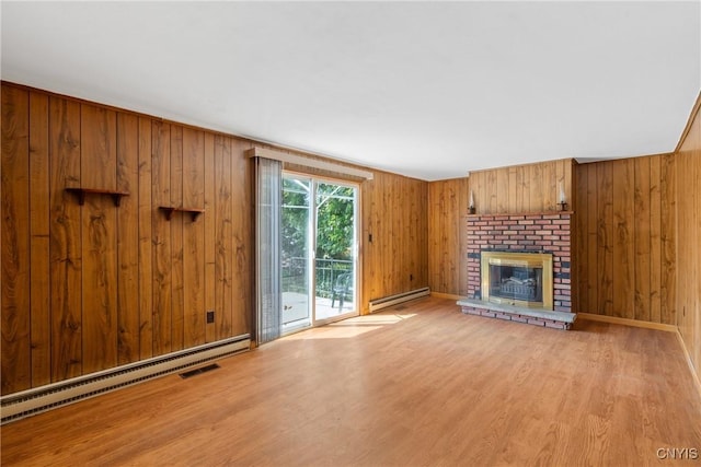 5539 Taormina Dr, Clay, NY 13041 - unfurnished living room featuring a baseboard radiator, light wood finished floors, a fireplace, and wood walls