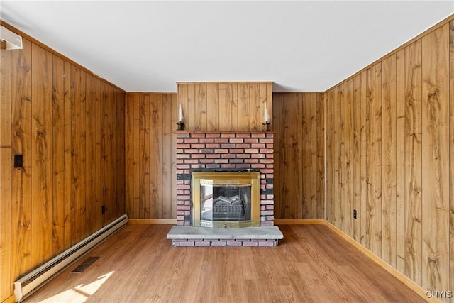 5539 Taormina Dr, Clay, NY 13041 - unfurnished living room featuring baseboard heating, wood finished floors, wooden walls, and a fireplace