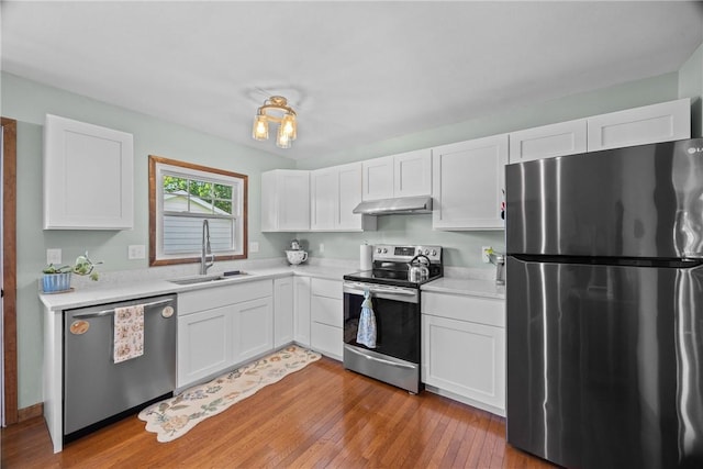 7980 Cedarwood Dr, Rome, NY 13440 - kitchen featuring appliances with stainless steel finishes, under cabinet range hood, light countertops, and white cabinets