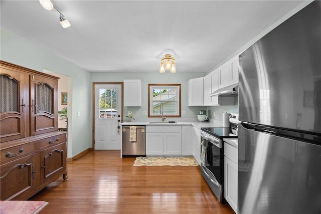 7980 Cedarwood Dr, Rome, NY 13440 - kitchen with stainless steel appliances, under cabinet range hood, white cabinets, light wood finished floors, and light countertops