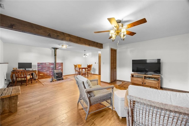 7980 Cedarwood Dr, Rome, NY 13440 - living area with ceiling fan, beamed ceiling, light wood-style flooring, and a wood stove