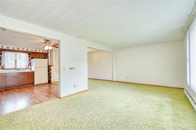 163 Auramar Dr, Irondequoit, NY 14609 - unfurnished living room with a ceiling fan, light colored carpet, a baseboard heating unit, light wood-type flooring, and baseboard heating