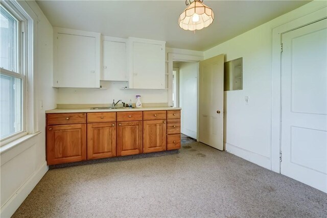1621 Bragg St, Lima, NY 14485 - kitchen with light countertops, brown cabinets, white cabinets, and light colored carpet