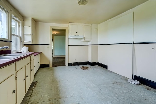 1621 Bragg St, Lima, NY 14485 - kitchen with under cabinet range hood, light flooring, and white cabinetry