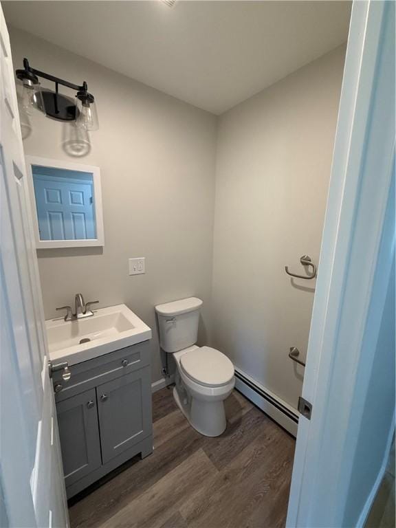 11948 River Rd, Corning, NY 14830 - half bathroom featuring a baseboard heating unit, wood finished floors, and vanity