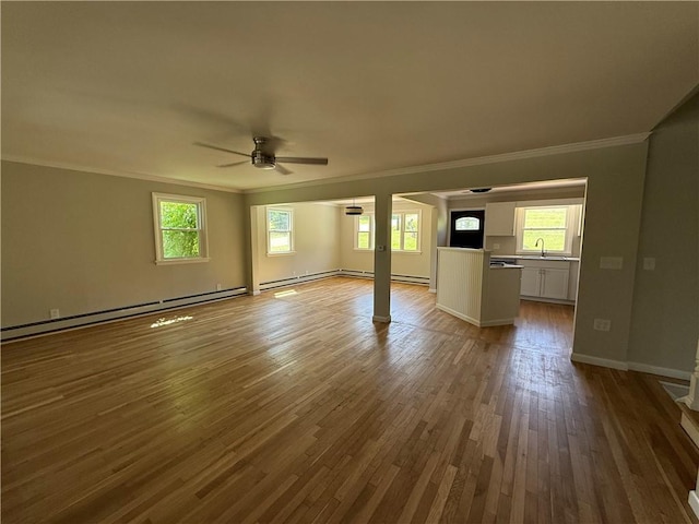 11948 River Rd, Corning, NY 14830 - unfurnished living room with baseboard heating, crown molding, a ceiling fan, wood finished floors, and plenty of natural light