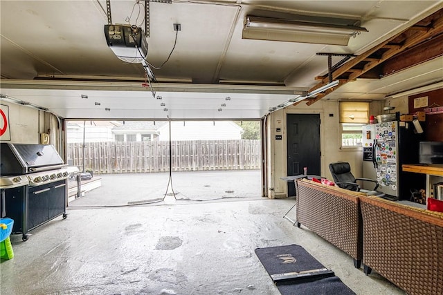 189 Hoover Rd, Irondequoit, NY 14617 - garage featuring a garage door opener and stainless steel refrigerator with ice dispenser