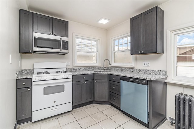 1570 Mount Hope Ave, Rochester, NY 14620 - kitchen featuring appliances with stainless steel finishes, radiator heating unit, light stone countertops, and light tile patterned floors