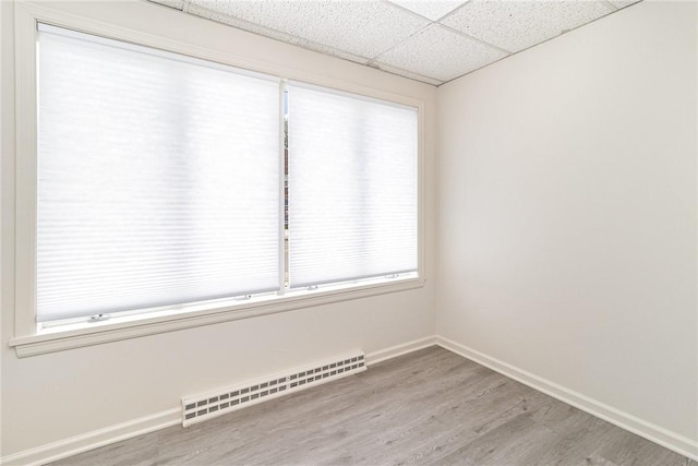 1570 Mount Hope Ave, Rochester, NY 14620 - unfurnished room featuring baseboard heating, wood finished floors, and a drop ceiling