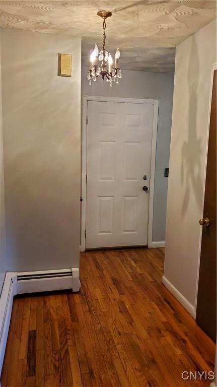582 Peck Rd, Sullivan, NY 13082 - doorway with a chandelier, wood finished floors, and a baseboard radiator