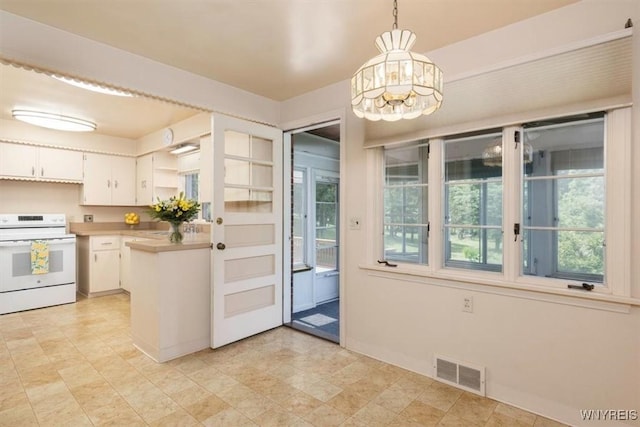 356 Union Rd, West Seneca, NY 14224 - kitchen featuring white electric range oven, plenty of natural light, white cabinets, and hanging light fixtures