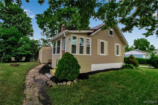 201 Ohio St, Ridgeway, NY 14103 - view of side of property featuring a chimney, a lawn, a shed, and an outdoor fire pit
